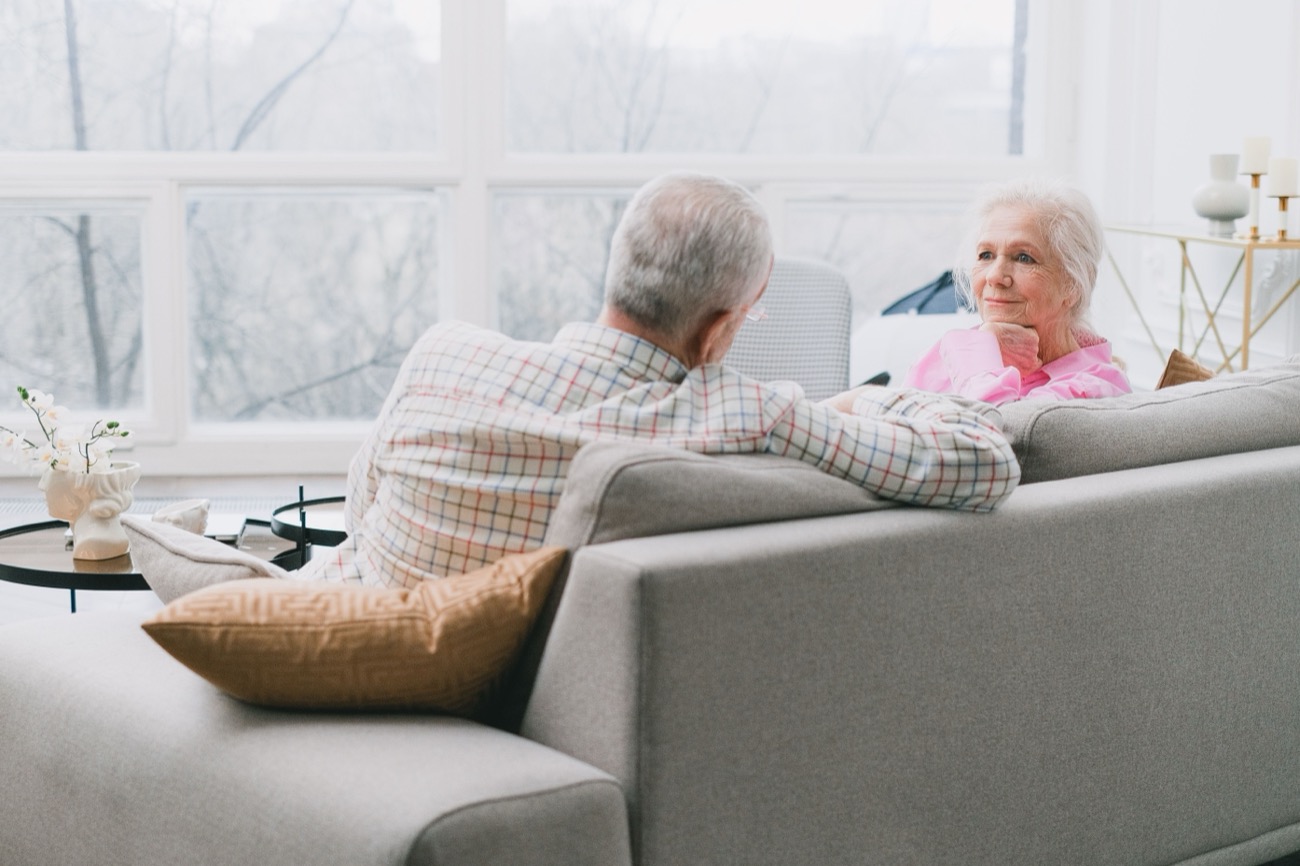 An older couple talking in the living room of their home